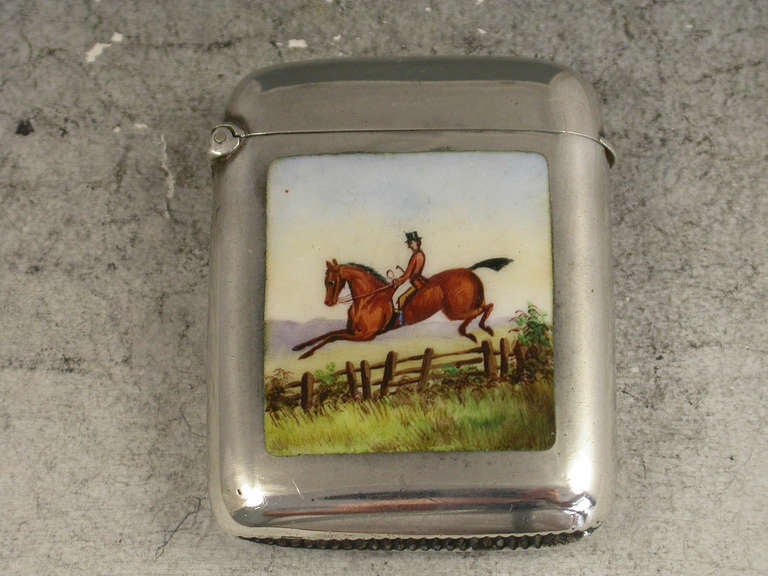 A good Victorian silver vesta case of rounded rectangular form with hinged flip-top lid, the face enamelled with a scene of a huntsman on horseback wearing a pink coat and black top hat, jumping a wooden fence. 

By Matthew John Jessop, London,