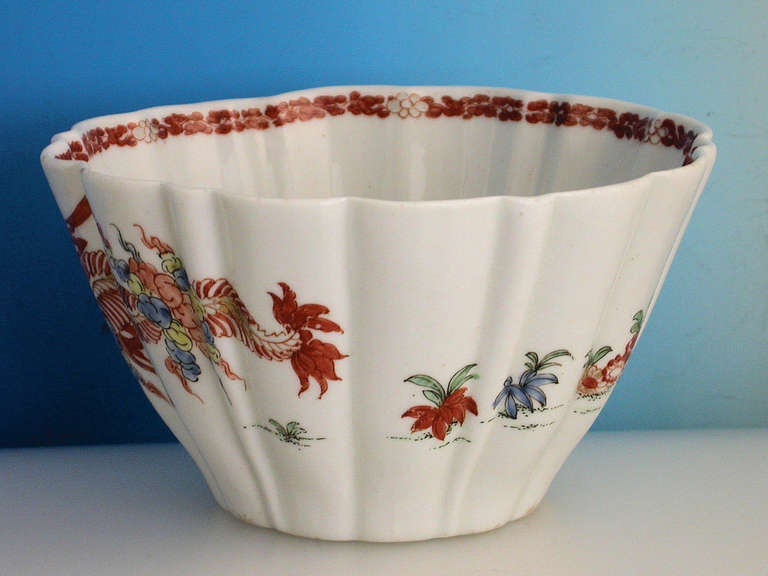 A very fine and rare early Worcester conical moulded Bowl with pleated flutes, painted in kakiemon style with the red crabs pattern depicting two crustaceans flanked by a ferocious dragon and growing plants, the interior with an iron red foliate
