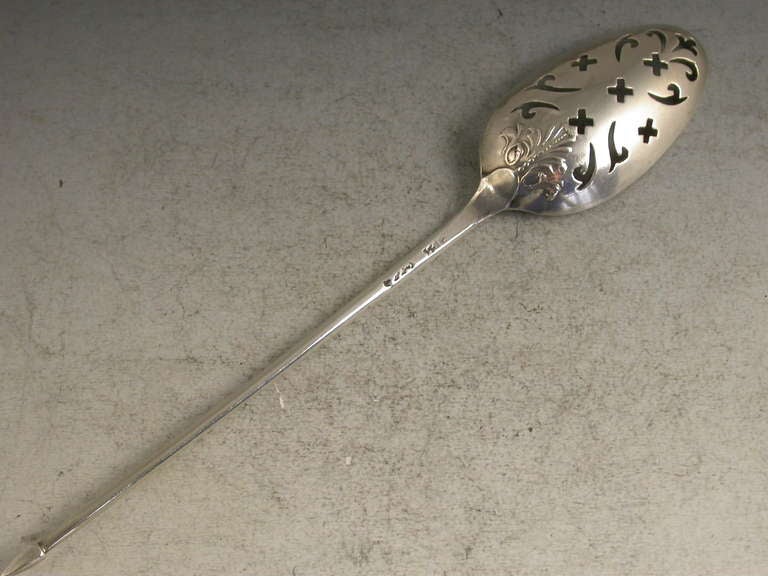 A fine George II 'fancy-back' silver Mote Spoon, the plain tapering handle terminating with a diamond point finial, the oval bowl pierced with scrolls crosslets and a fleur-de-lys and chased with an anthemion type shell in the rococo style.

By