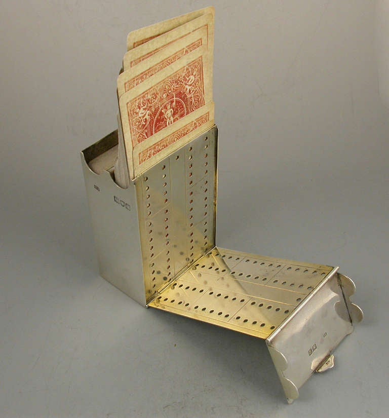 A rare Victorian silver combined Cribbage Board and Twin-Pack Card Box, the cover and side hinging open to form the gilded cribbage scoring board with drilled holes to accept pegs. The main body housing two packs of playing cards. Engraved with