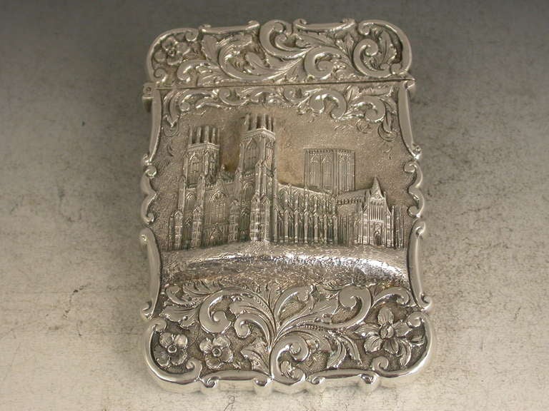 A fine Victorian silver Castle-Top Card Case of shaped rectangular form with chased and embossed foliate scroll decoration both front and back. The front with a depiction of York Minster in high relief.

By Nathaniel Mills, Birmingham, 1845. 