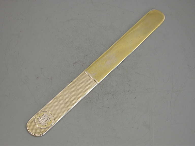 A good quality Edwardian silver gilt paper knife of narrow rectangular form, the handle with engine turned decoration and a circular cartouche engraved with contemporary script initials.

By Charles & George Asprey, London, 1903

In good