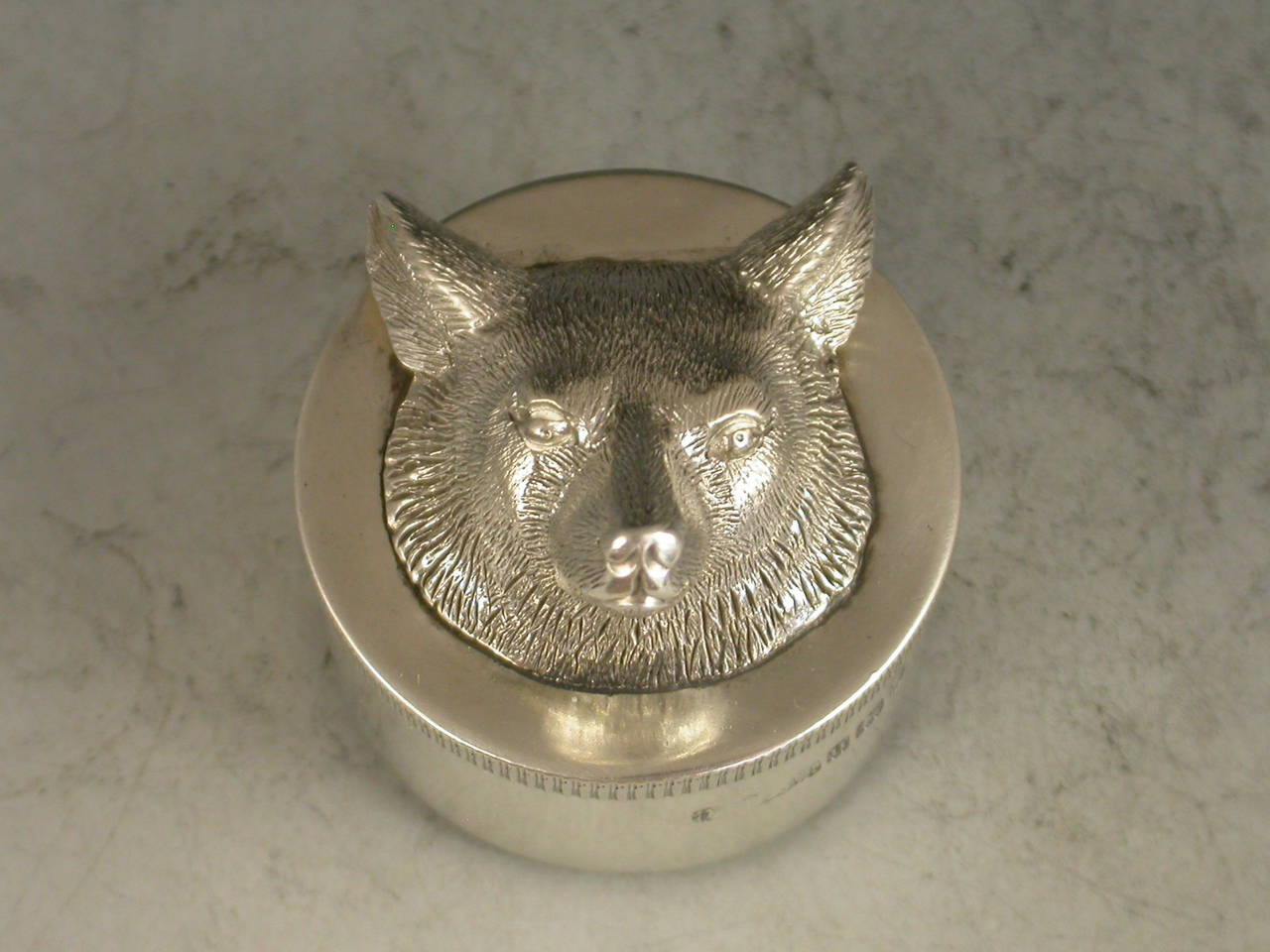 A nice quality early 20th century silver Pocket Pencil Sharpener of circular form with pull-off lid. Complete with original vintage Dux German metal pencil sharpener. The lid applied with a cast silver Foxes head. 

By A Barrett & Sons Ltd,