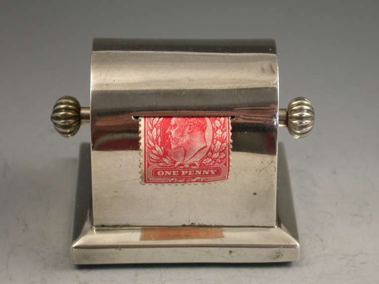 A rare Edwardian silver single coil Stamp Dispenser, of plain rectangular form with domed top and single slot to the front. The stamps are dispensed by turning the knobs at either side. Pull-out wooden base.

By Charles & George Asprey, London,
