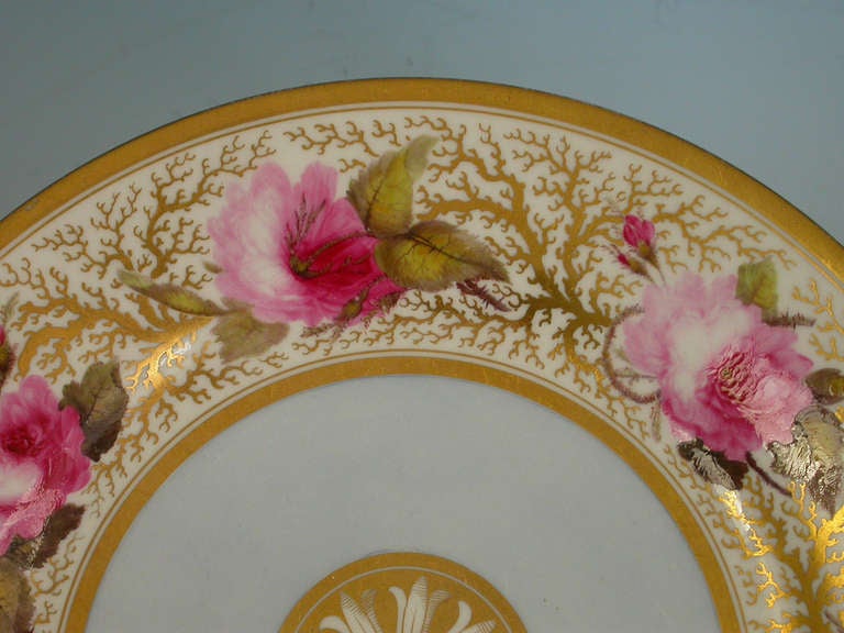 A good Flight Barr & Barr Worcester Dessert Plate, painted in polychrome enamels enriched with gilt. The central gilt harebell medallion enclosed by a sky blue surround within a border of fully blown Billingsley style roses on a seeweed ground, gilt