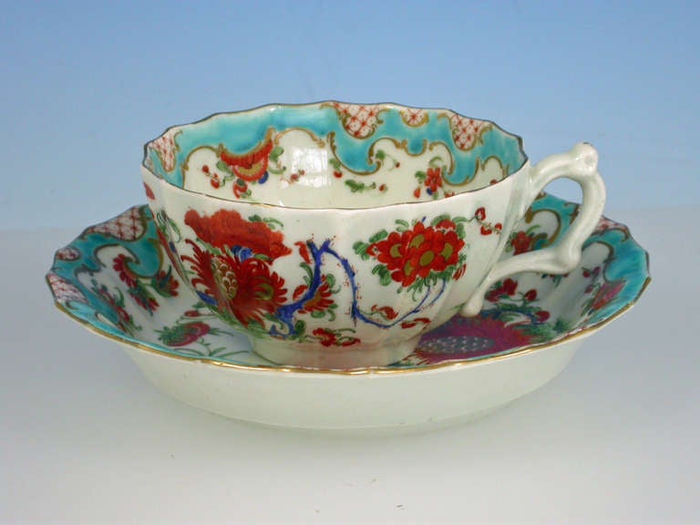 
A fine First Period Worcester Teacup and Saucer of fluted form with scroll handle, painted in Kakiemon style with the so-called 