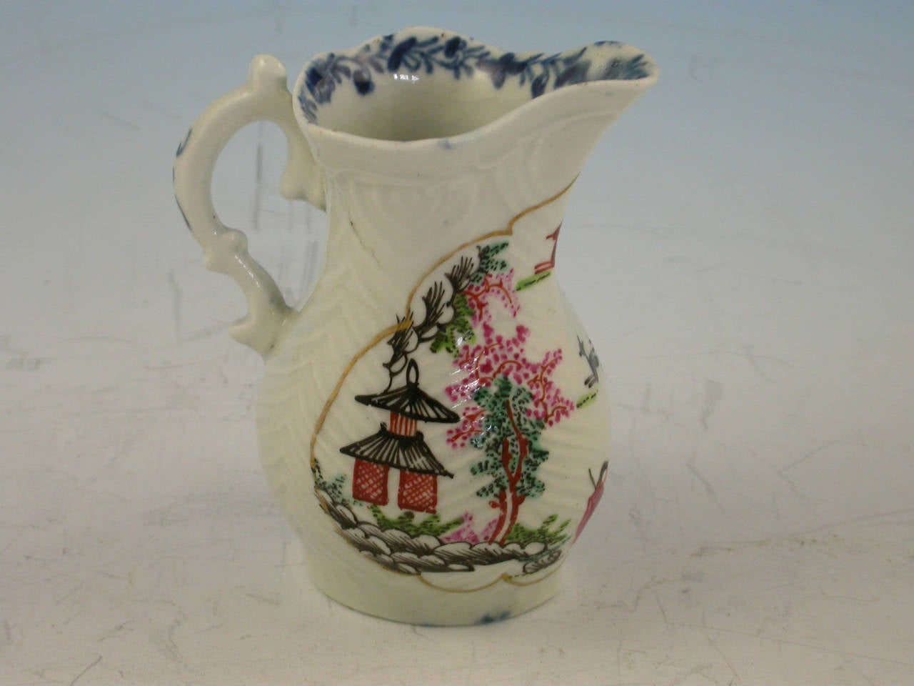 An early Worcester feather moulded Cream Jug, painted in polychrome enamels with a version of the so called 