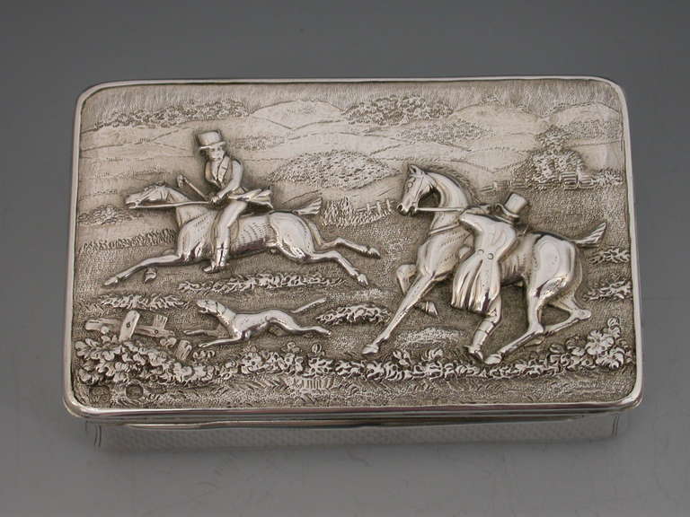 A good quality Victorian silver Snuff Box of compressed rectangular form with engine turned decoration to the base and sides, the lid inset with a hallmarked raised high relief panel depicting a hunting scene with two huntsman, horses and hounds in