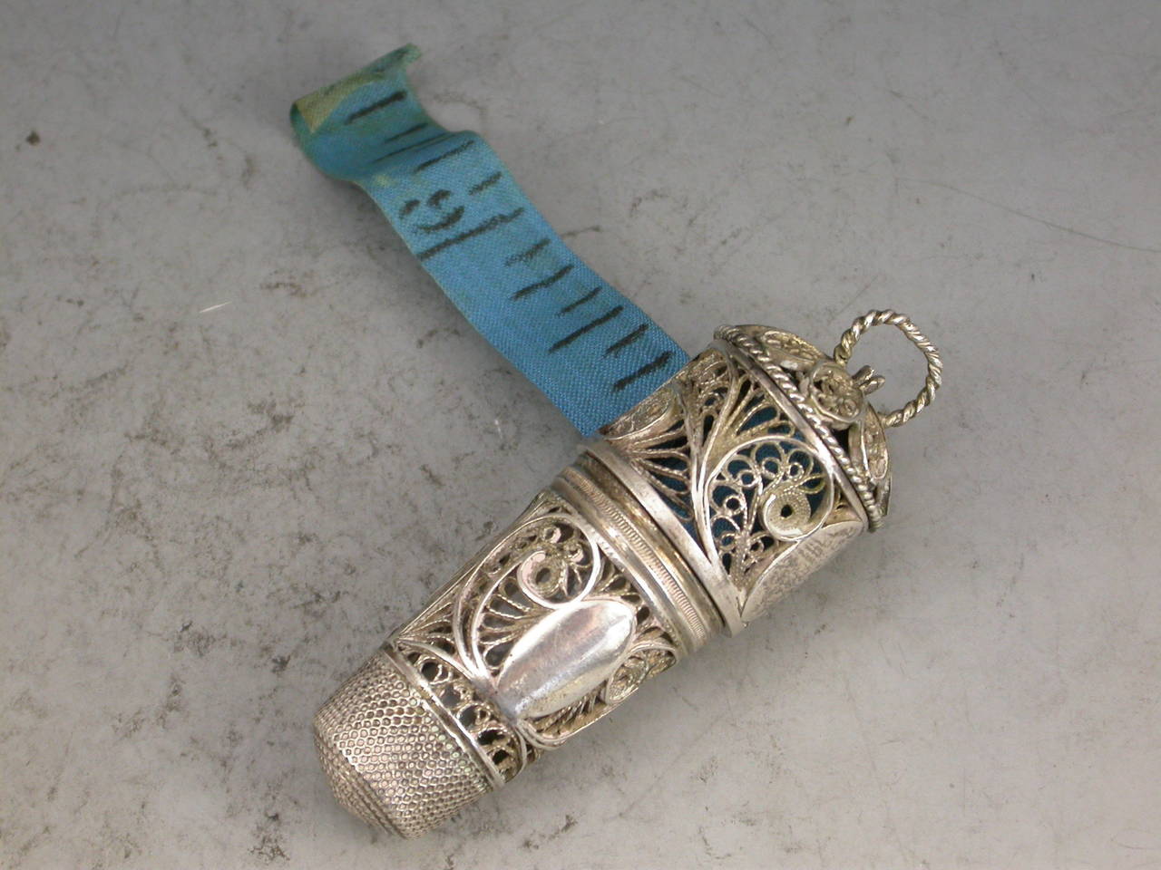 A rare George III silver filigree combined Scent Bottle Holder, Thimble and Tape Measure complete with original glass scent bottle and stopper and blue silk tape. 

Unmarked c1800