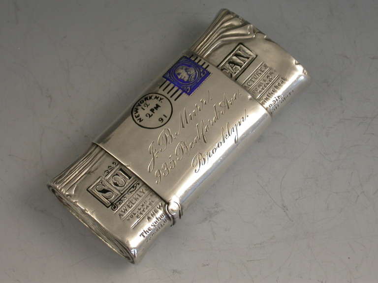 A fine and rare 19th century sterling silver and enamel Vesta Case made in the form of rolled up copy of the Scientific American Newspaper wrapped with an address label complete with enamel stamp and post mark. The reverse enamelled with three red
