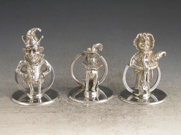 A fine quality and rare set three Edwardian cast silver Menu Holders formed as Mr Punch, his wife Judy and Dog Toby, on plain circular bases. 

By Horance Woodward & Co, London, 1910 - 1911