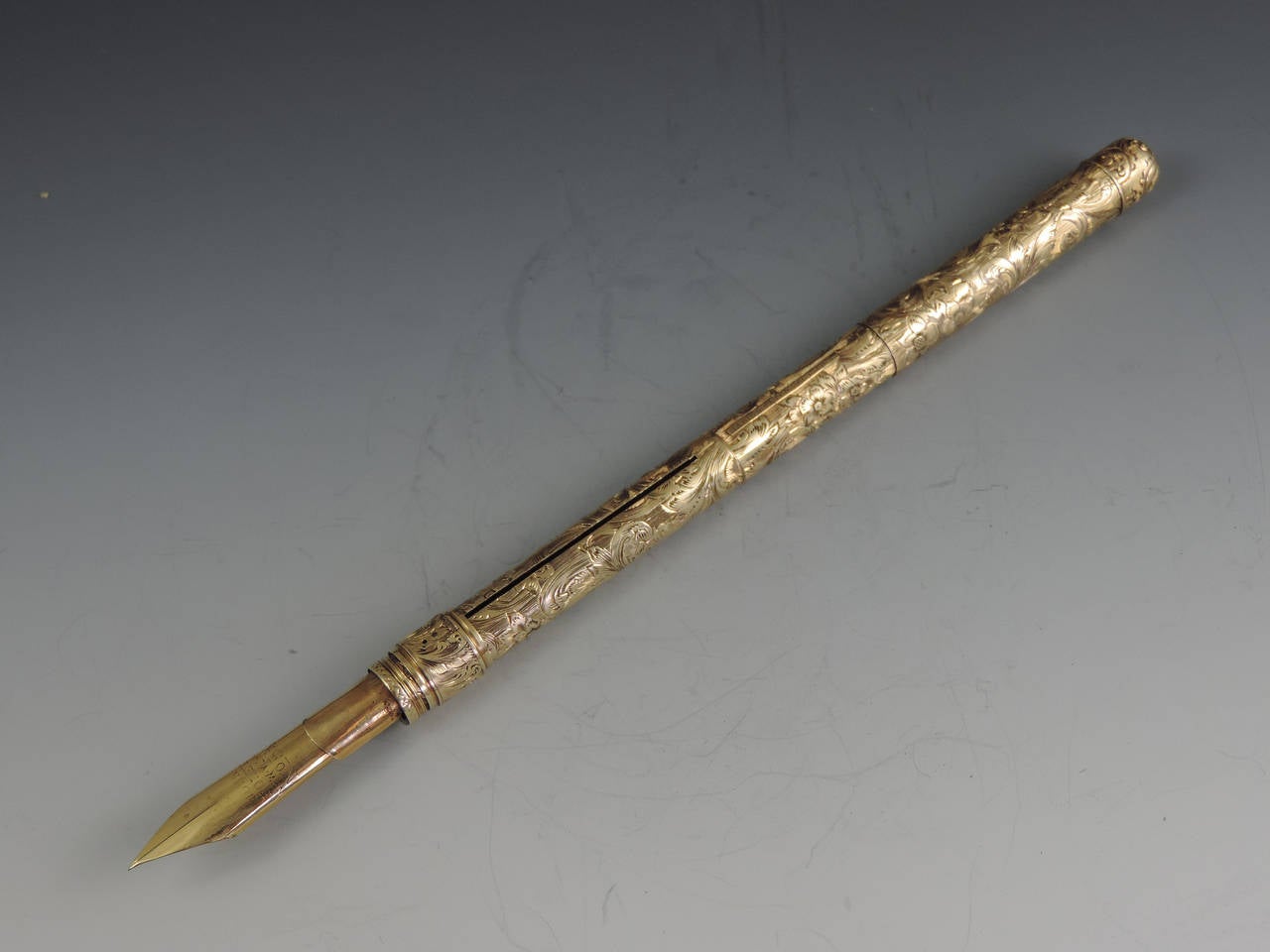 An exceptionally fine quality mid 19th century American 14 carat gold combination Sliding Gold Pen and Propelling Pencil with integral telescopic extending mechanism to the shaft. The cylindrical body superbly hand chased with foliate scroll work,