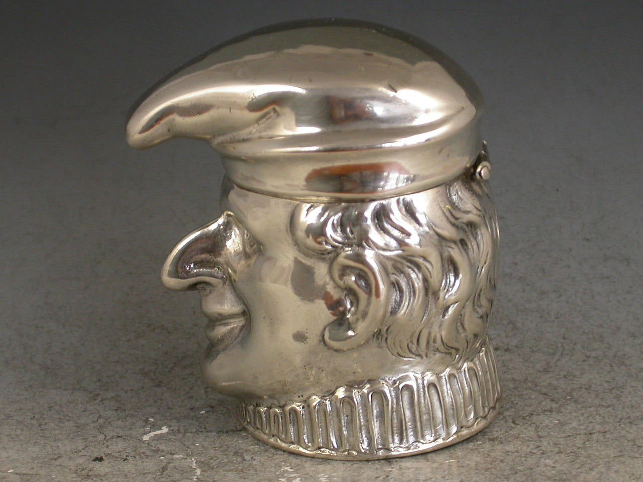 An Edwardian German novelty silver Box or possibly Vesta Case modelled as Mr Punch, his hat forming the hinged lid, silver gilt interior. The ruff could be used as a striker 

Importers mark for M Freidlander & Co, Chester, 1908