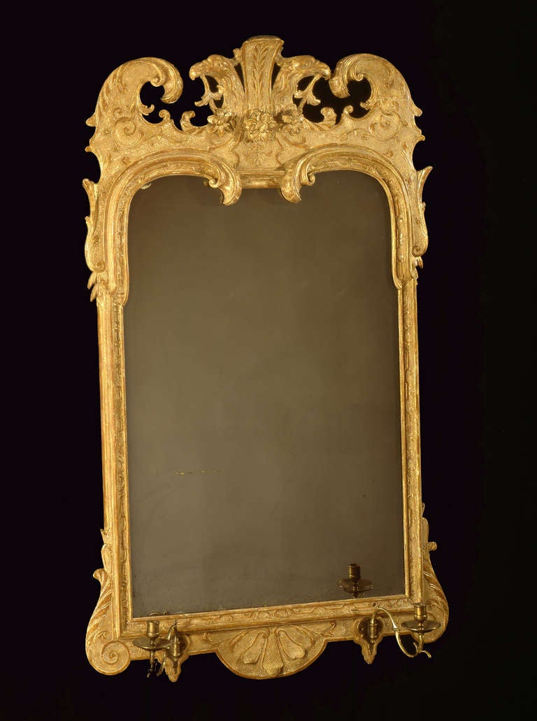 Mostly original gilding; bevelled glass is probably original, but resilvered.

The curved scrolls dipping into the glass at the top are nowadays always associated with the maker John Belchier. Belchier has documented work at a house called Erdigg,