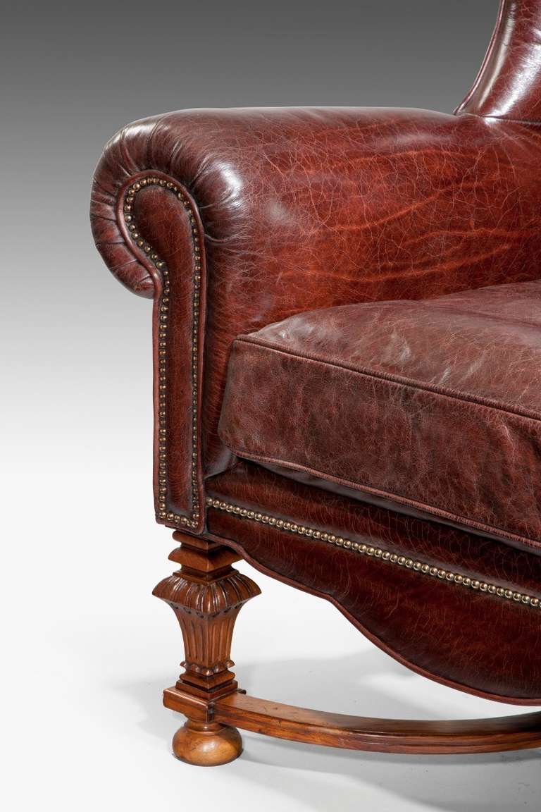 A very grand pair of oversized gentlemens walnut wing armchairs, reupholstered in distressed leather.