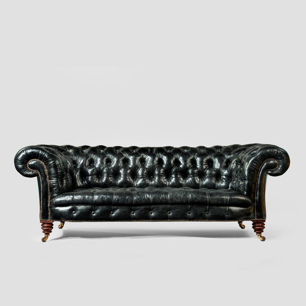 20th Century A pair of black leather Chesterfield sofas by Shoolbred