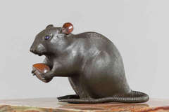 A Meiji period bronze of a rat holding a chestnut
