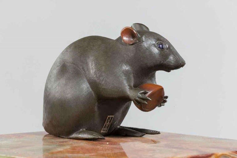 Japanese A Meiji period bronze of a rat holding a chestnut