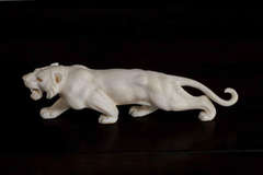A Meiji period ivory Okimono of a stalking tiger with mother of pearl eyes.