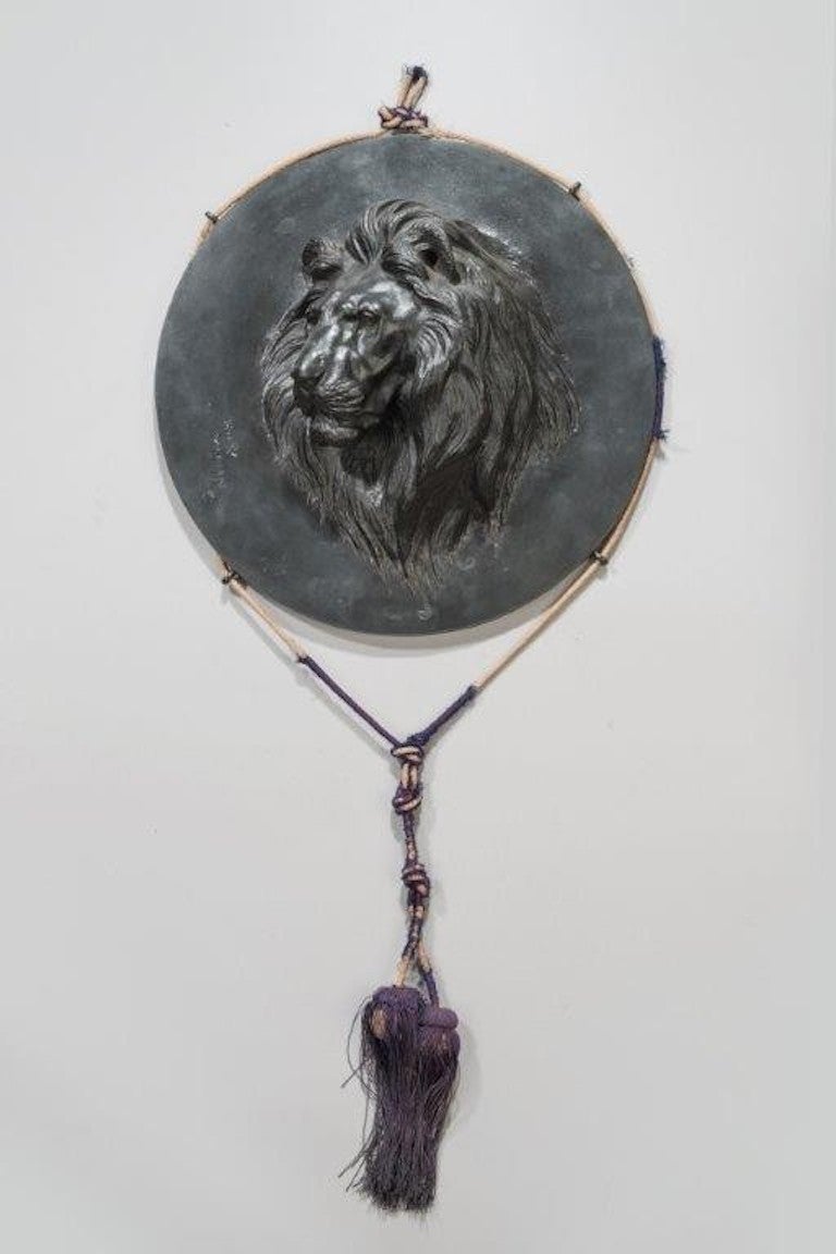 A meiji period Japanese bronze roundel of a roaring tiger.