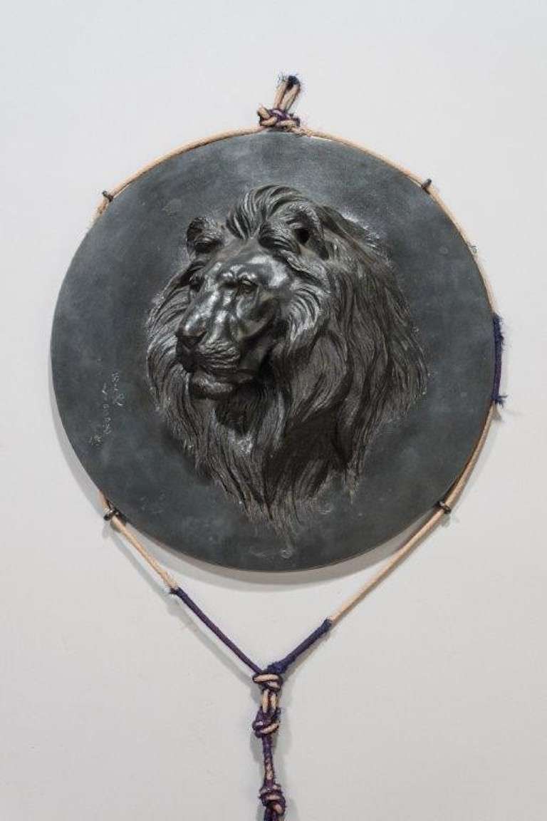 A meiji period Japanese bronze roundel of a roaring tiger. Signed to the rim.