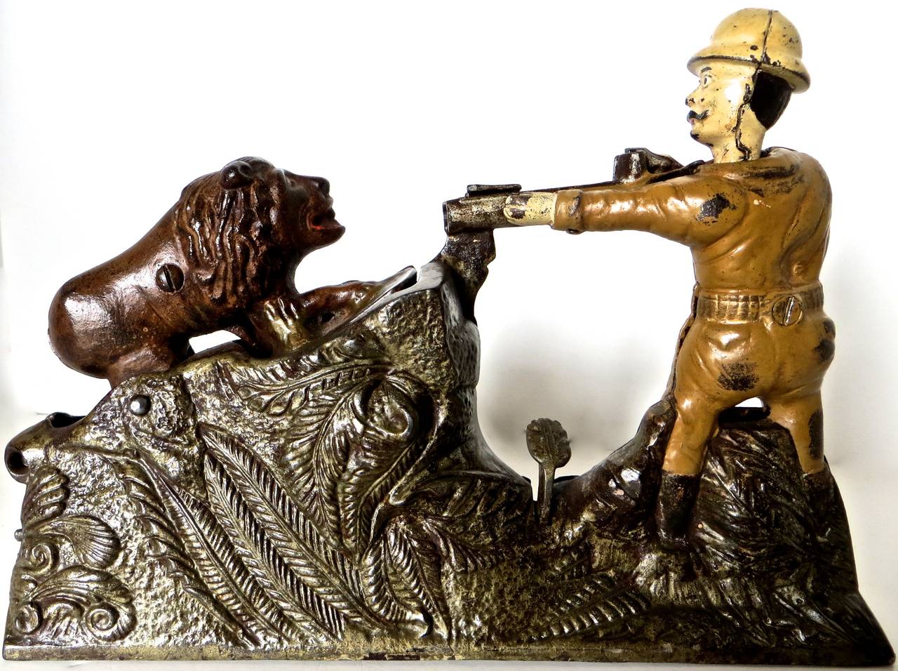 Manufactured in 1911 by the J. & E. Stevens Company in Cromwell, Connecticut, this cast iron mechanical bank depicts President Teddy Roosevelt aiming his rifle at a lion. Roosevelt is well-known for his affinity towards big game hunting, and