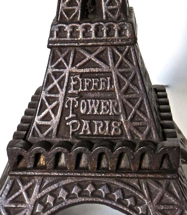 This is the very rare (taller) version of "Eiffel Tower" still bank, listed on page 112 in Andy Moore's "The Penny Bank Book" as an "F" rated bank, which is the rarest connotation. The manufacturer is unclear (likely