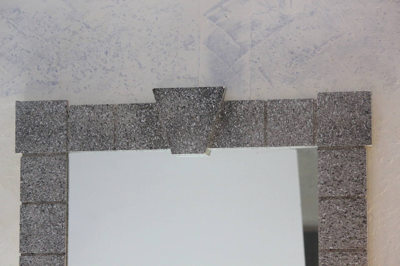 Nicely detailed large 1970s vintage Mid-Century Modern mirror--grey speckled faux stone matte finish architectural delineated square faux stone tiles around the perimeter with a keystone header and larger keystone corner tiles. Handsome