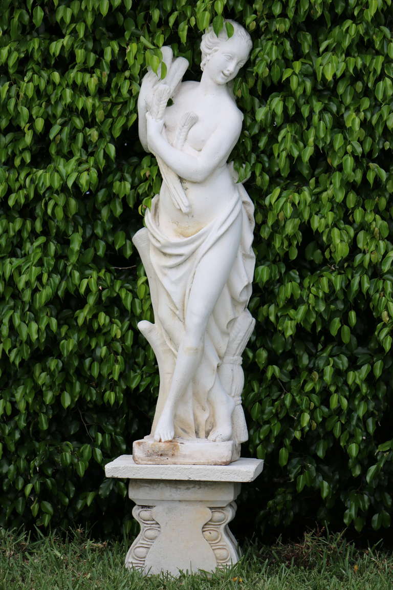 This vintage cast stone lovely goddess stands for Abundance of the Autumn Harvest. She is holding sheaves of wheat, surrounded by wheat at the base of her legs - classical cast stone statue of 'Autumn from the Four Seasons series is beautifully