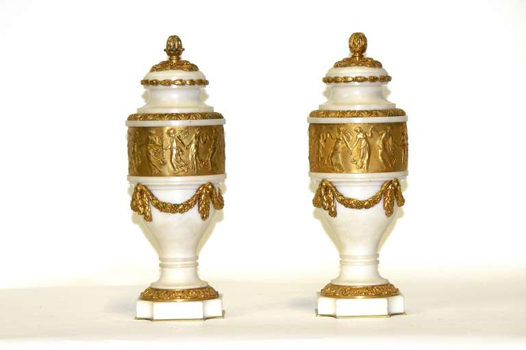 A Tout de Force!- From a Conoisseur to your Conoisseur collection!

Spectacular! an important rare pair of 19th century, circa 1860 Louis XVI neoclassic white marble cassolettes with a centre gilt bronze band of dancing Grecian ladies in relief-by