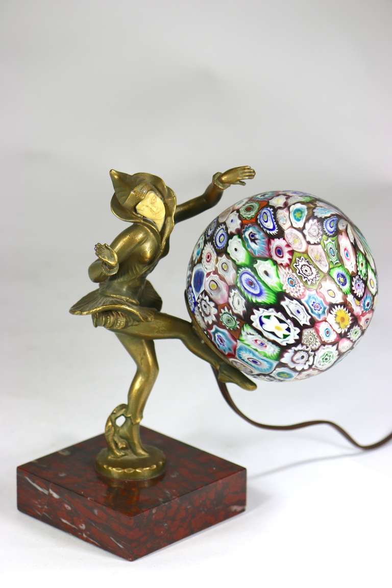 Sprinkle Pixie Dust All Around for Happiness!
First half of the 20th century, circa 1920's A Ignacio Gallo 'Pixie' Dancer Art Deco Figural Table Lamp in French Bronze Finish with ivorine face. Her Foot Supports A Large Original Millefiori Ball