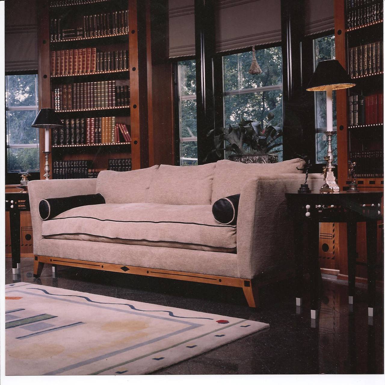 A superbly designed 1980’s Contemporary Sofa upholstered in a Donghia chenille linen, black leather welt trim on a single down and feather seat cushion and three down and feather back cushions. The Maple Wood Frame and Legs bearing a Black Stenciled