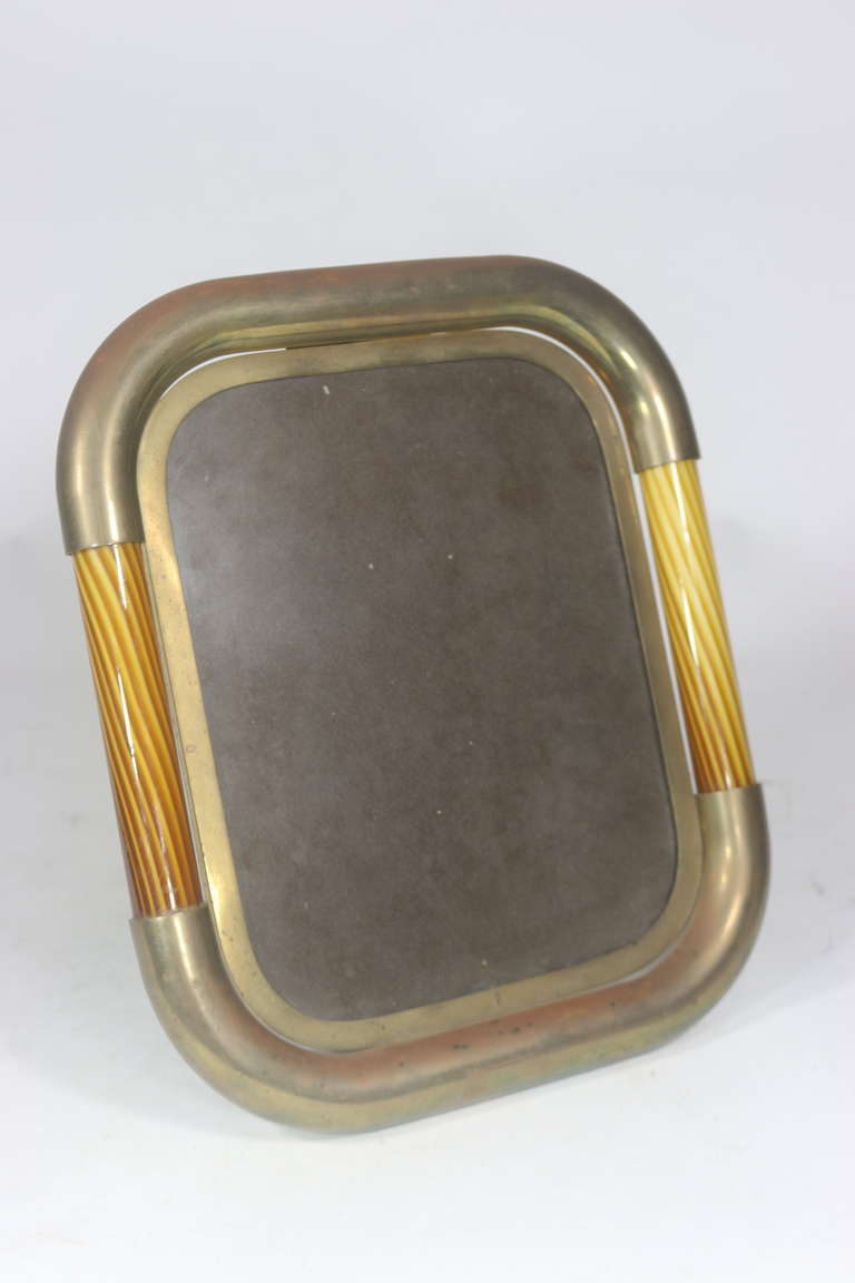 Outstanding original 1950s Tomasso Barbi Murano Mid-Century Modern Italian-with a brass plaque inscribed Tomasso Barbi made in Italy.
Substantial brass frame with art glass inset curvilinear edges, polished brass interior frame with easel-style