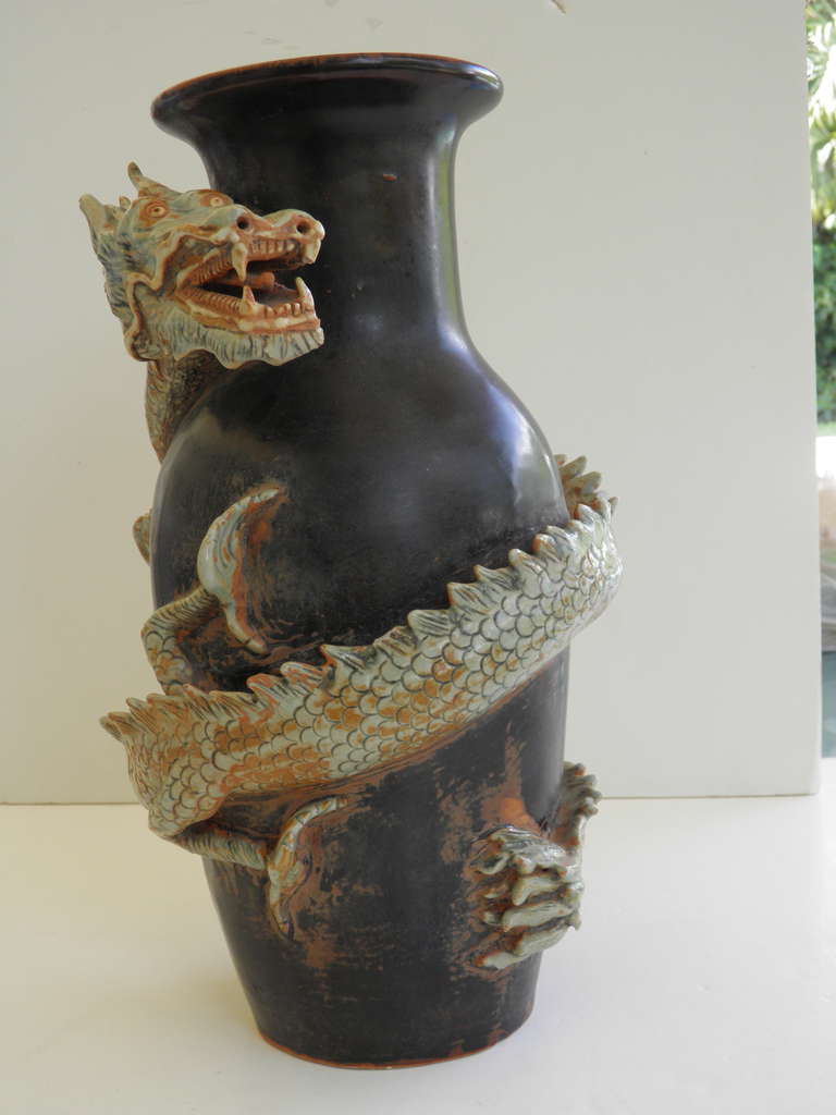A large dynamic gorgeous ceramic Thai dragon vase. A black ground patina with a figurative dragon-detailed with scales, claws, teeth all in high relief wrapped around the body of the vase. Makes a very impressive statement.
for Your Decor--on a