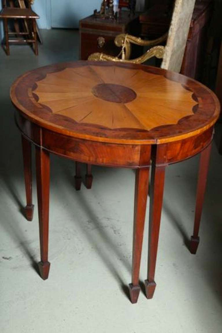 A highly figured pair of George III style 19th century demilune console tables with the most remarkable Mellowed wood figured faux marquetry top and  distressed satinwood, figured mahogany, elm burl. The top has a distinctive paterae, tapered spade