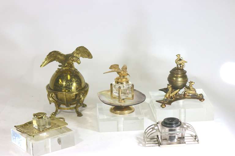 Superb set of four distinctive inkwells as shown, (an Art Nouveau crystal and gilt brass, a aged bronze Griffin neoclassic, An Arts & Crafts chrome and old black plastic ink holder, a large neoclassic brass globe with eagle atop which opens to a