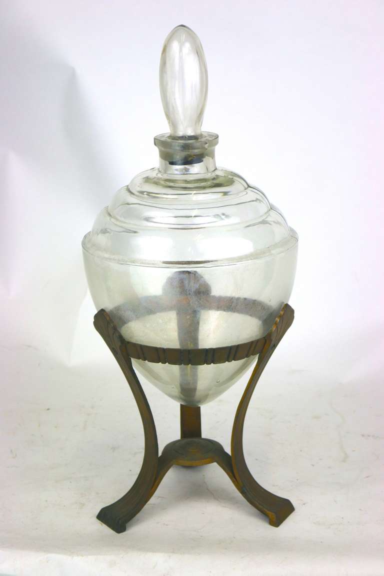 A circa 1930 Art Deco apothecary display glass globe and base. The table top show globe and stopper designed to hold colored water for display in an apothecary shop in original aluminum base. Mfg. Owens-Illinois Co. Beautiful for your vanity or