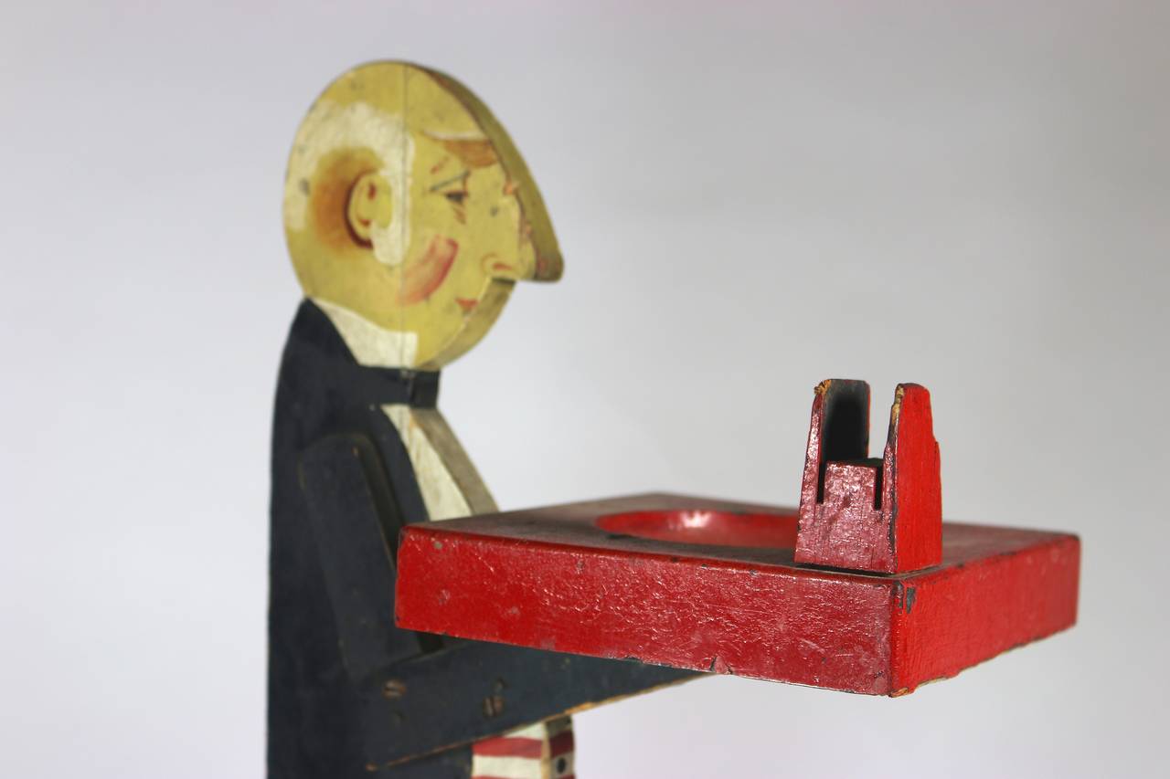 1930s Butler Smoking Stand with Original Paint holding a Wood Tray with a matchbox holder attached--vivid colors, Nicely painted Face--Great Aura. Can be a candy or food tray or business card holder, candles, etc. etc.
One of the many