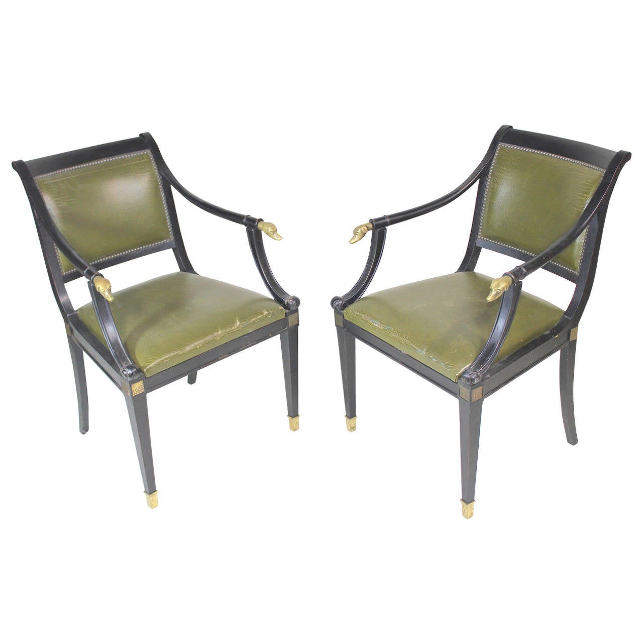 1930s a chic superb ebonized wood pair of highly detailed armchairs. Distinctive shapes and forms define their graceful elegance. Comfy deep slung backs with sloping arms ending in fabulous brass dog head finials down to the carved floret trim,