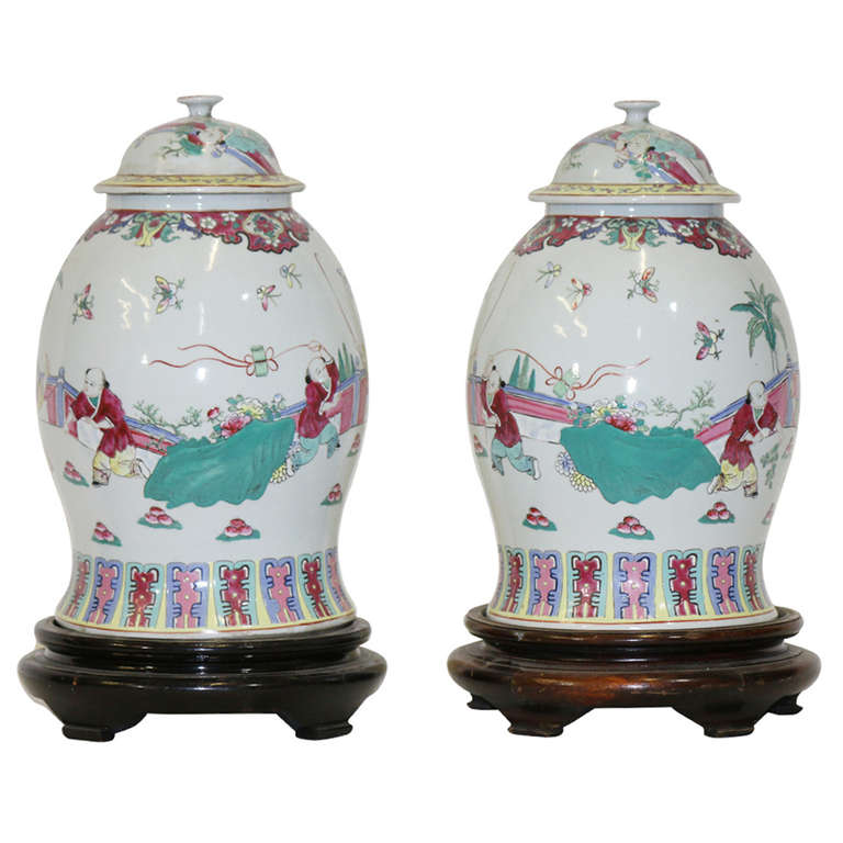 A pair of large famille rose baluster jar and covers. They have then both been beautifully hand-decorated in the Famille rose palette with over-glaze polychrome enamels using pinks, yellow, green, blues and a ruby red. (Five color palette) on