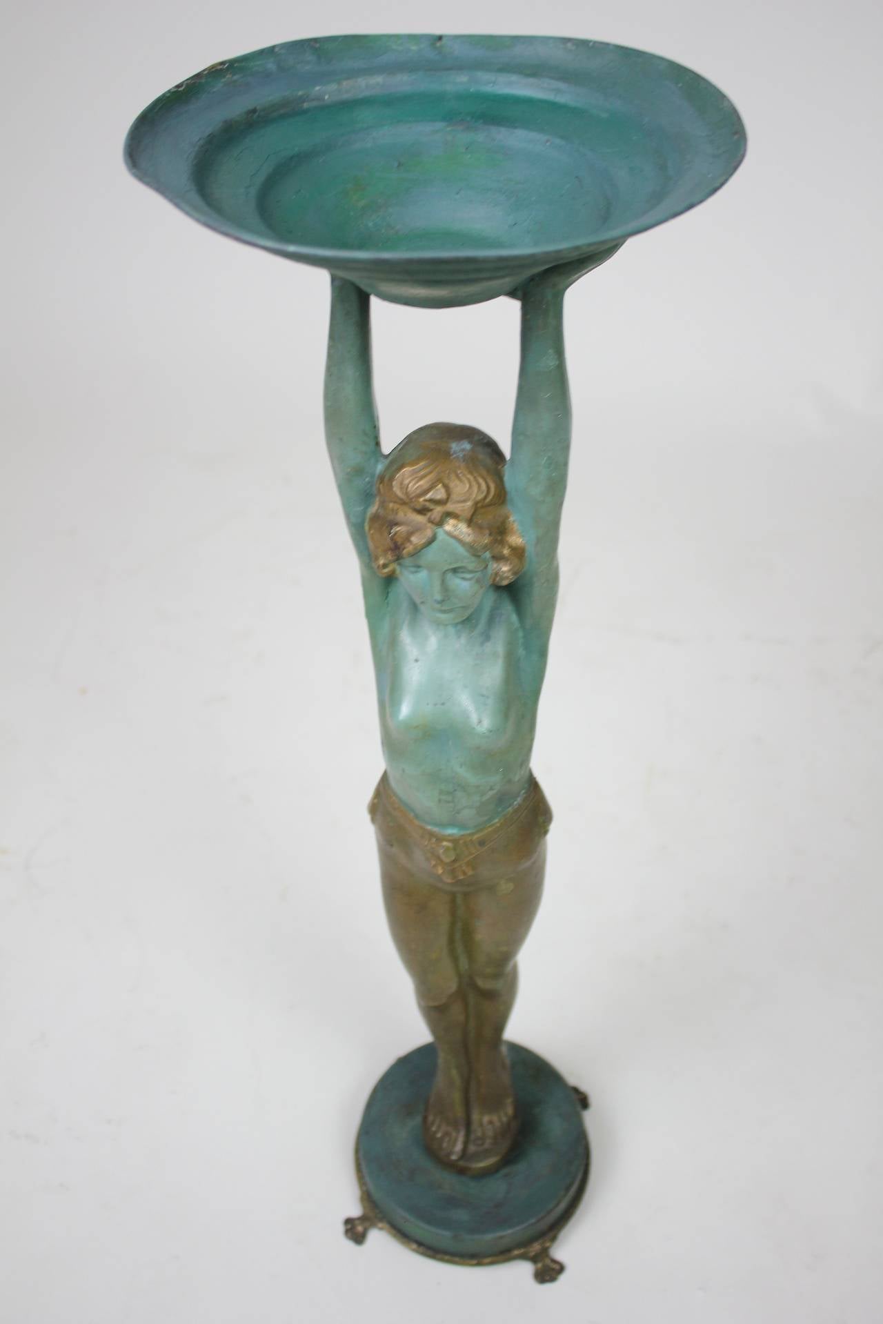An artful mixed metal Art Deco Lady holding, with arms raised, a round bowl tray aloft a round base with paw feet by Everlite of Brooklyn, New York. A creative sculpture which may have been a smoking stand, we have used in the serving of fruit or