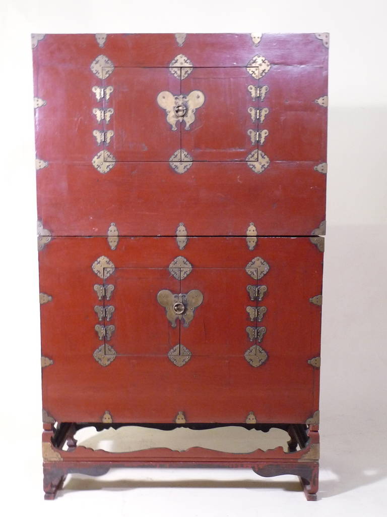 A rare beautiful late 18th/19th century pair of Korean aged patina red lacquer blanket chests (Bandaji) with etched aged brass metal hardware- 6 butterfly hinges and a large butterfly center-each on a conforming stand-(both stands are like the left