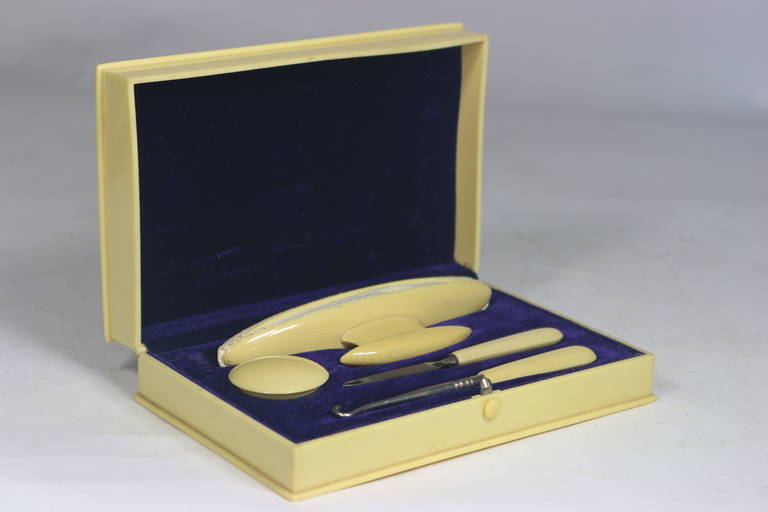 A turn of the century ivory celluloid box with conforming blue velvet compartments for the five-piece nail kit tool dresser set-marked imperial brands on the top of the buffing tool. Rich blue velvet lining.  R
Provenance-assembled from our
