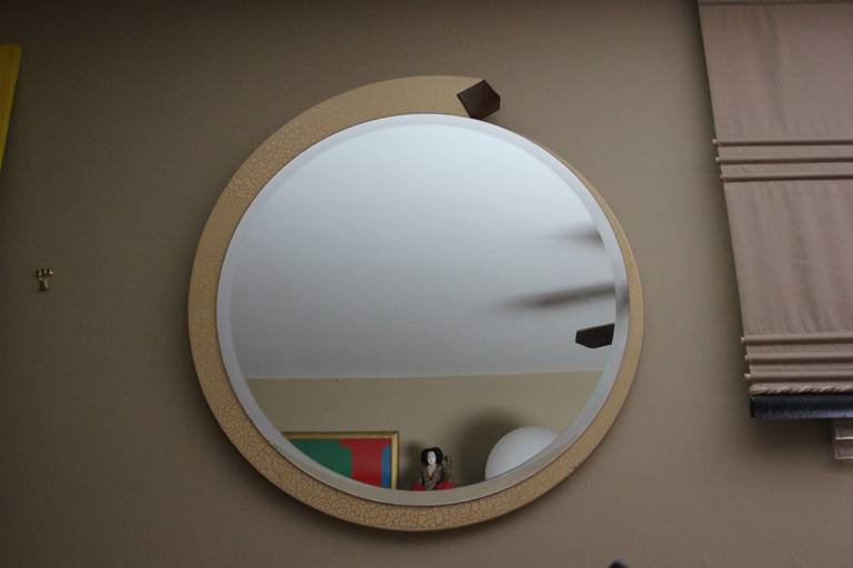 Stunning clever design signed 1989 limited edition Mirror by craftsman L. Weitzman in stunning ivory crackle finish frame beveled circular mirror with mahogany diamond detail. Mounts to the wall, has a ball bearing swivel mechanism. The mirror