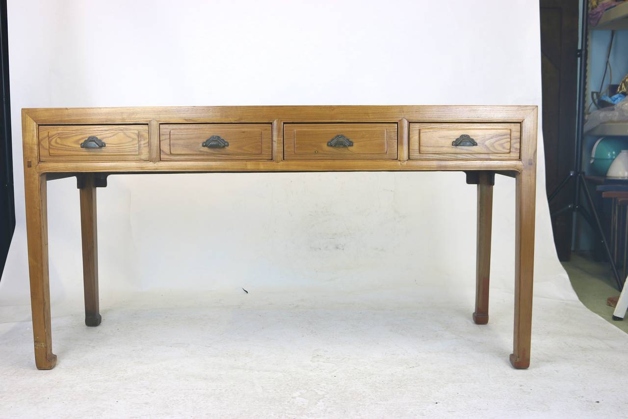 This is a beautiful light richly figured lustrous elmwood four drawer console table, writing table, desk. Mortise and tenon joinery. Dovetail drawer construction. Original Iron work pulls. Can be a console table or a writing table as a desk. The