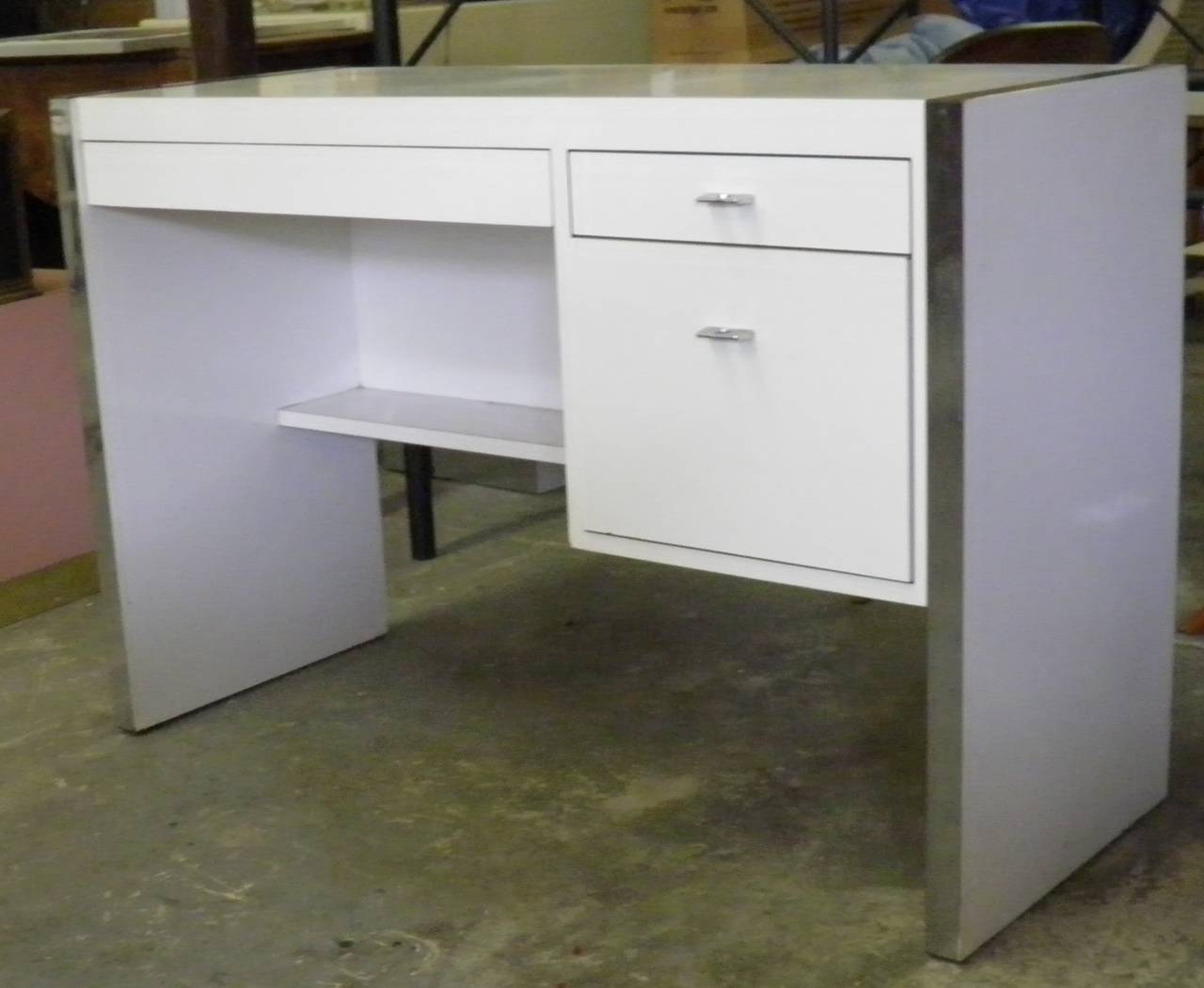 1960s vintage Modern Milo Baughman Style White Lacquered Desk with Stylish Chrome Banded Edges and Chrome Pulls- Great Storage--inside the large pencil drawer is green felt lining with a light oak desk accessory compartment, the pedestal has an oak