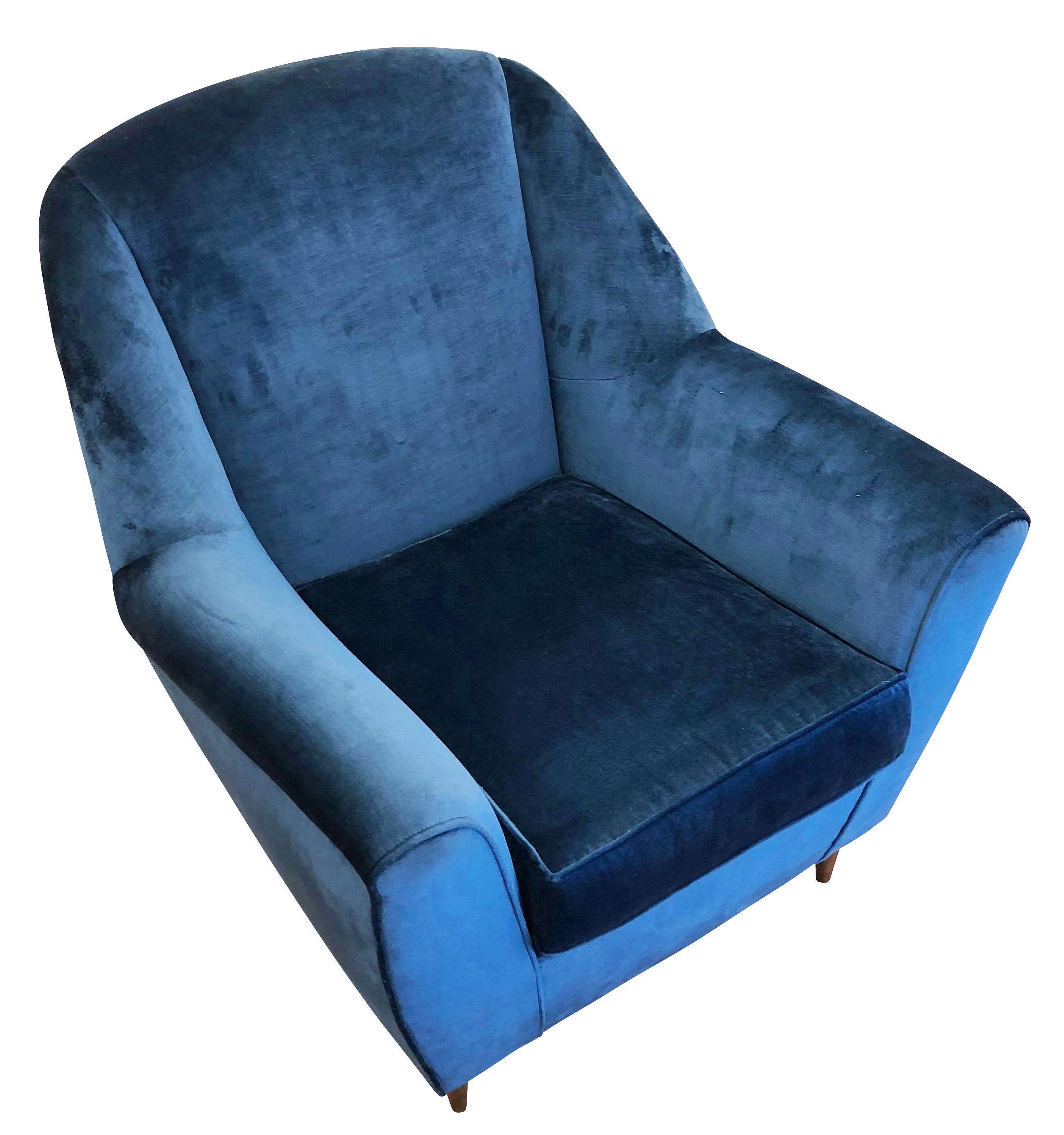 Midcentury lounge chair with a wide seat and slanted back. Original feet are wood but can be replaced with brass ones on request. Has been upholstered in a blue velvet for display purposes. 

Condition: Re-upholstered

Measures: Width