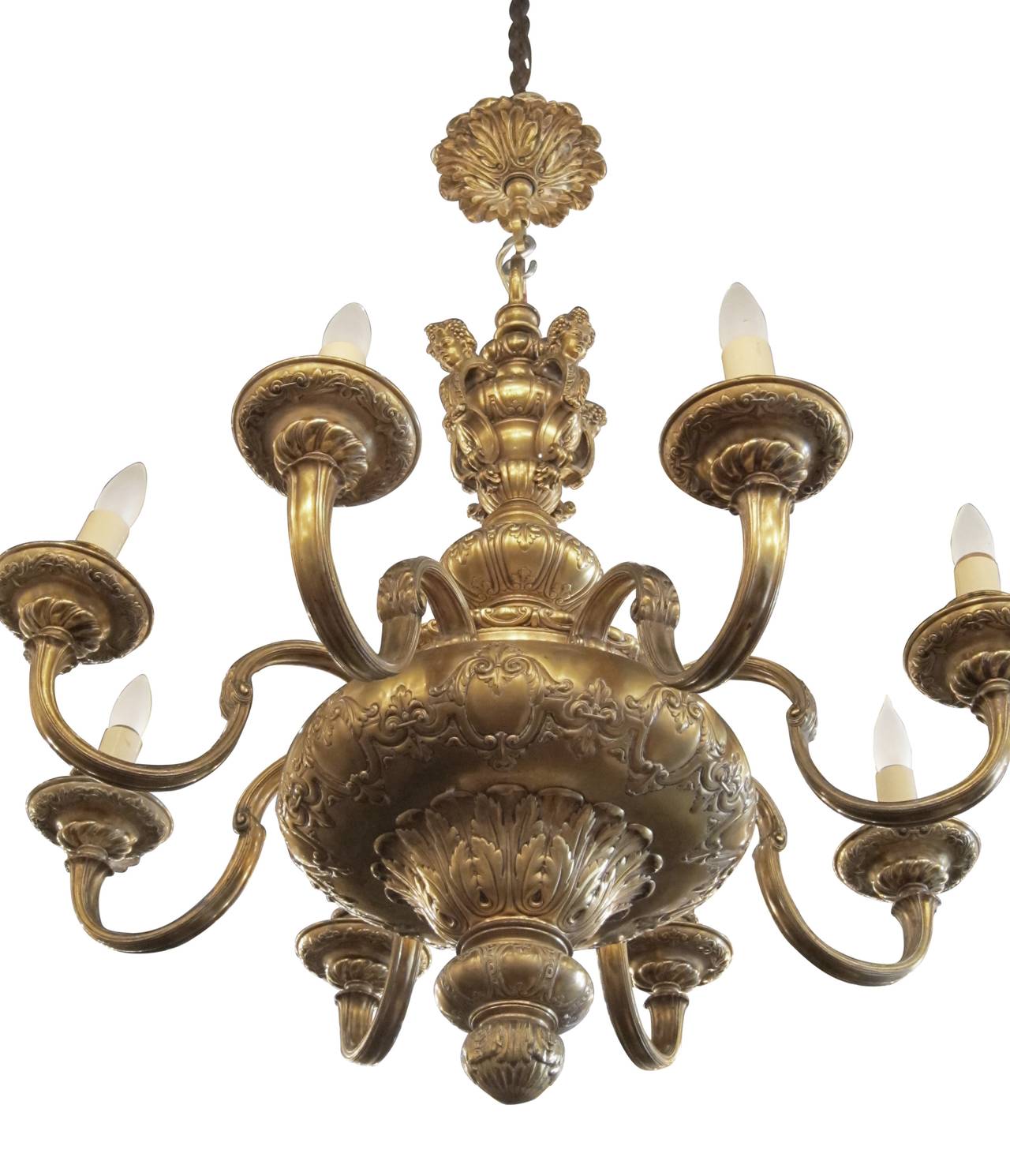Gold-plated eight-arm chandelier with relief work on main well, cherubic figures on top well, and highly detailed work on finial. French made from the 1900s. This can be seen at our 2420 Broadway location on the upper west side in Manhattan.