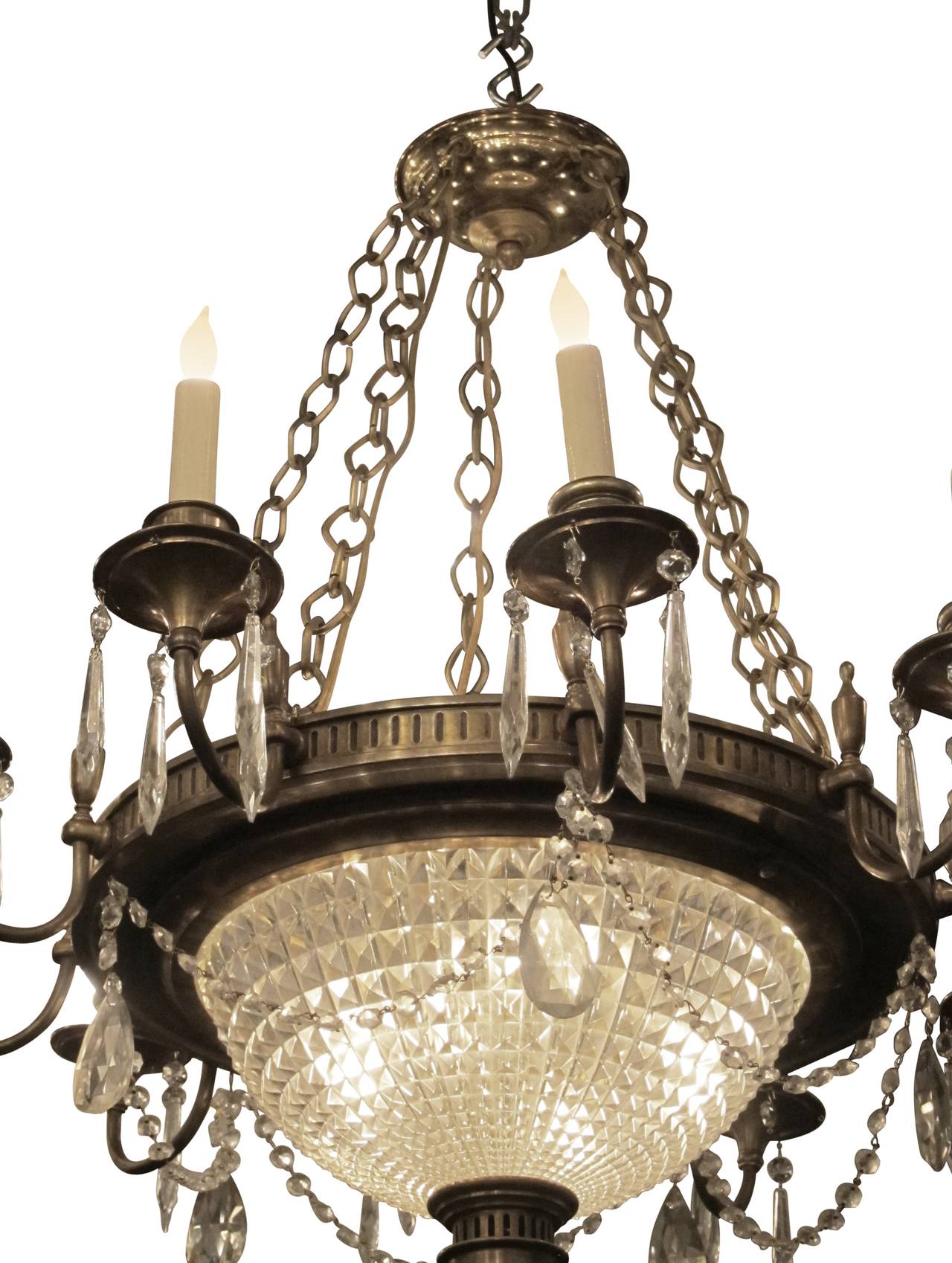 Bronze and crystal twelve-arm Empire style French chandelier with crystal swags from 1920s. This can be seen at our 2420 Broadway location on the upper west side in Manhattan.
