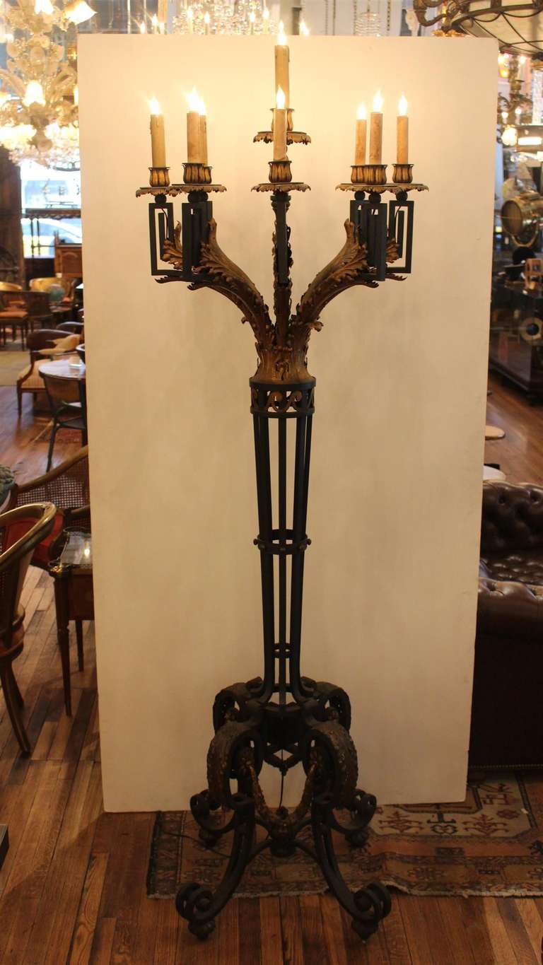 This pair of wrought iron sconces are large scale, standing candelabras or torchieres with intricate detailing. Each has nine lights. They were installed in the Fountainebleau Hotel when it opened in 1954. The Fountainebleau Hotel was designed by